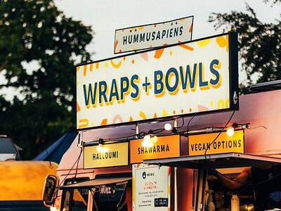 A lit wraps and bowls stall at dusk