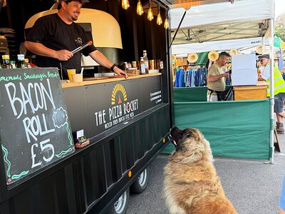 A caterer serving from a wood-fired pizza trailer